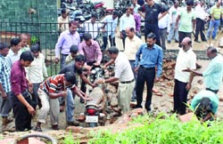 People remove a motorcycle from the debris in New Delhi on Tuesday. Tribune photo: Manas Ranjan Bhui