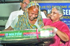 Chief Minister Sheila Dikshit distributes a free gas stove to a BPL card holder in New Delhi on Tuesday. Tribune photo: Manas Ranjan Bhui