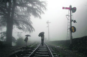 People walk on a railway track in dense fog in Shimla on Tuesday.
