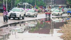Vehicles pass by a waterlogged stretch of the Satwari-Gangyal road