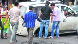 a vehicle is stuck as a portion of a road caves in in Jammu on Tuesday