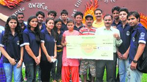 Members of the Nav Sankalp donate a cheque for Rs 10,000 to Deepa at the DAV College, Sector 10, in Chandigarh on Wednesday. 