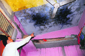 A resident shows the leaking roof of his house at the EWS colony at Sector 37 in Chandigarh. 