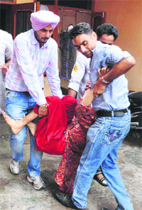 Activists of the Anti-Corruption and Human Rights Association rescue Jaswinder Kaur from her house at Balongi village in Mohali on Wednesday.