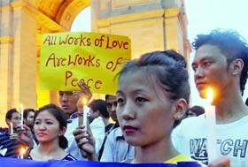Members of two social groups--Delhi Solidarity Group and Citizens Collective Against Sexual Assault--take out a candle march to condemn the violence in Assam and the attacks on people of the northeast, at the India Gate in New Delhi on Wednesday