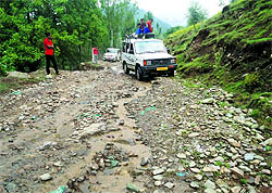 Vehicles pass through the potholed Kupwara-Batpora road