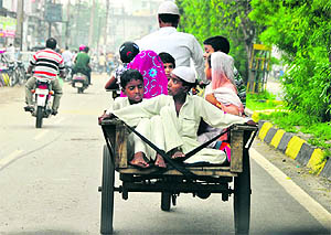 A family travels on an indigenous motor cart in Jodhewal Basti