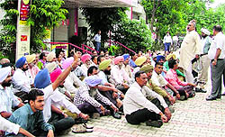 Employees of postal department sitting on a dharna outside the head post office in Ludhiana on Wednesday