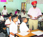 KS  Pannu, Director-General of School Education, checks copies of students at a government school in Jalandhar district  on Wednesday. 