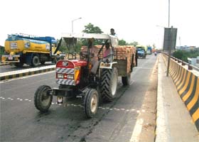 A tractor-trailer transports construction material on a city road