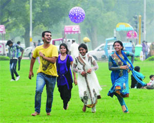 Youngsters enjoy the pleasant weather on the lawns of India Gate in New Delhi on Thursday.