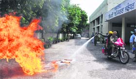 Fire Department employees present a demonstration of a motorcycle equipped with shoulder-mountable foam-filled fire extinguishers at the District Administrative Complex in Jalandhar on Thursday