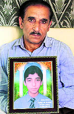 Mohd Ashrif Mattoo holds his son Tufails photograph