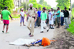 A policeman at the spot where two persons were run over by a speeding garbage collection truck in Ludhiana on Thursday