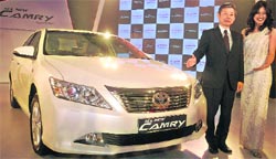 Toyota Kirloskar Motor MD Hiroshi Nakagawa poses with the upgraded Camry premium sedan at its India launch in New Delhi on Friday.  Tribune photo by Manas R. Bhui