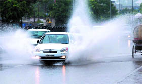 A car makes its way through the accumulated rainwater on Goniana road in Bathinda on Friday.