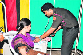 A doctor examines a patient during a camp on the occasion of AWWA Day at Army Hospital at Roorkee. 