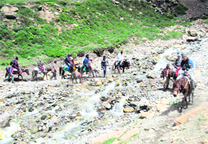 Kailash Mansarowar pilgrims cross a rivulet during their pilgrimage.