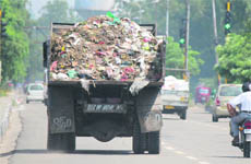 A truck belonging to the Jammu Municipal Corporation carries garbage in Jammu. 