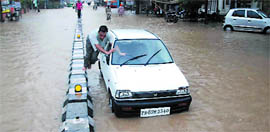 A man pushes his car after it broke down on the waterlogged Multania road in Bathinda after heavy rains lashed the city on Saturday.