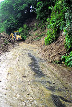 A bulldozer removes debris from the Bordkuwalu road near Kangra on Saturday