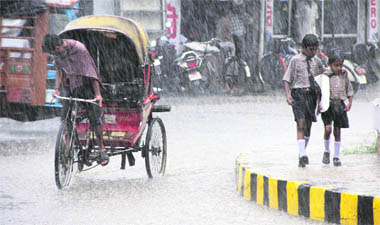 Schoolchildren and a rickshaw-puller caught in a downpour in Jalandhar on Saturday. 