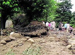 Villagers try to retrieve household goods from the debris of a damaged mud house in the Bathindi area in Kathua on Saturday