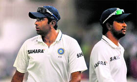 R Ashwin (L) and Pragyan Ojha leave the ground after rain stopped play on the third day.