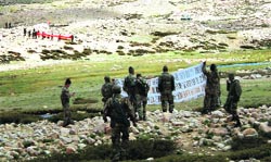Indian troops show a banner asking Chinese troops to withdraw. The banner says: In keeping with the spirit of the agreement we are withdrawing. Please go back and dont move forward. In the far background, the Chinese soldiers show their own banner A Tribune photo