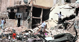 Residents search for their belongings in the rubble of their houses following shelling by Syrian forces in Aleppo.