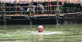A man wades through floodwaters at a village outside Pathein in the Irrawaddy delta region of Myanmar.