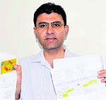 Victim Rakesh Kumar shows his valid ATM card in Chandigarh on Sunday