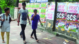 Students pass by the Wall of Democracy at DU in Delhi on Sunday. 