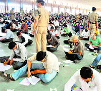 Candidates take examination for the posts of police assistant driver sitting on the floor without mats or chairs in Haridwar on Sunday