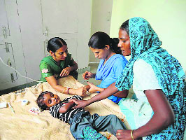 A nurse attends to a child at Badalgarh village, near Ratia, in Fatehabad on Sunday. 