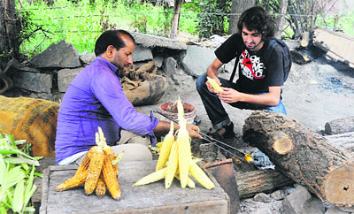 A tourist buys maize at Boulevard road on the banks of the Dal Lake in Srinagar on Sunday.