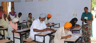 Old and young, men and women, all sit for an exam conducted by the National Adult Literacy Mission, in Government Middle School at Kaler village of Faridkot district. 