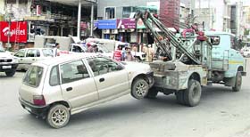 A traffic police vehicle tows a car, which was wrongly parked in Model Town market in Jalandhar on Monday