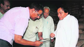 Consumer Affairs and Public Distribution Minister Qamar Ali Akhoon inspects foodgrain at a CAPD store, following damage to the stock due to rain, in Jammu on Sunday.
