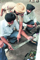 DCP GS Toor and other officials examine the murder weapon in Ludhiana on Monday.