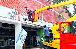 MC officials remove glow signboards from the Sector 7 market on Madhya Marg in Chandigarh on Tuesday