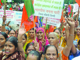 Members of poor families of the city and activists of the BJP demonstrate against the Delhi government for its alleged failure to provide cheap ration and other facilities to the poor in South Delhi, at Shahidi Park near ITO in New Delhi on Tuesday.