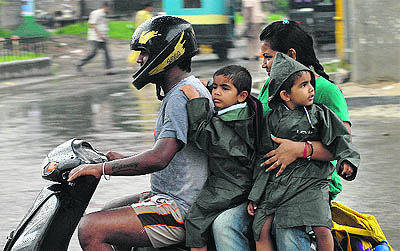 A family returns home on a rainy afternoon on Tuesday in Jalandhar. 