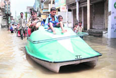 Former councillor Vijay Kumar ferries children to school at a flooded street in Bathinda.
