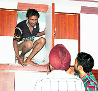 A member of a gang of vehicle-lifters, Davinder Singh, who hid himself in a cupboard, being arrested by the police at Chheharta in Amritsar