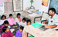 A teacher takes a class in the Head Teachers office with students sitting on a mat at Government Elementary School, Maqboolpura, in Amritsar