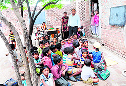 A teacher takes a class in the open while students sit on mats at Government Elementary School, Maqboolpura in Amritsar