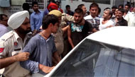 Policemen take the snatchers towards the car to rescue them from the anger of the crowd in Ganesha Basti on Thursday