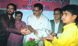Mussoorie MLA Ganesh Joshi (in white) distributes sports kit among students of Sanskrit Vidyalaya on Thursday.