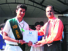 The Principal of Delhi Public School awards a student at an investiture ceremony in Dehradun 